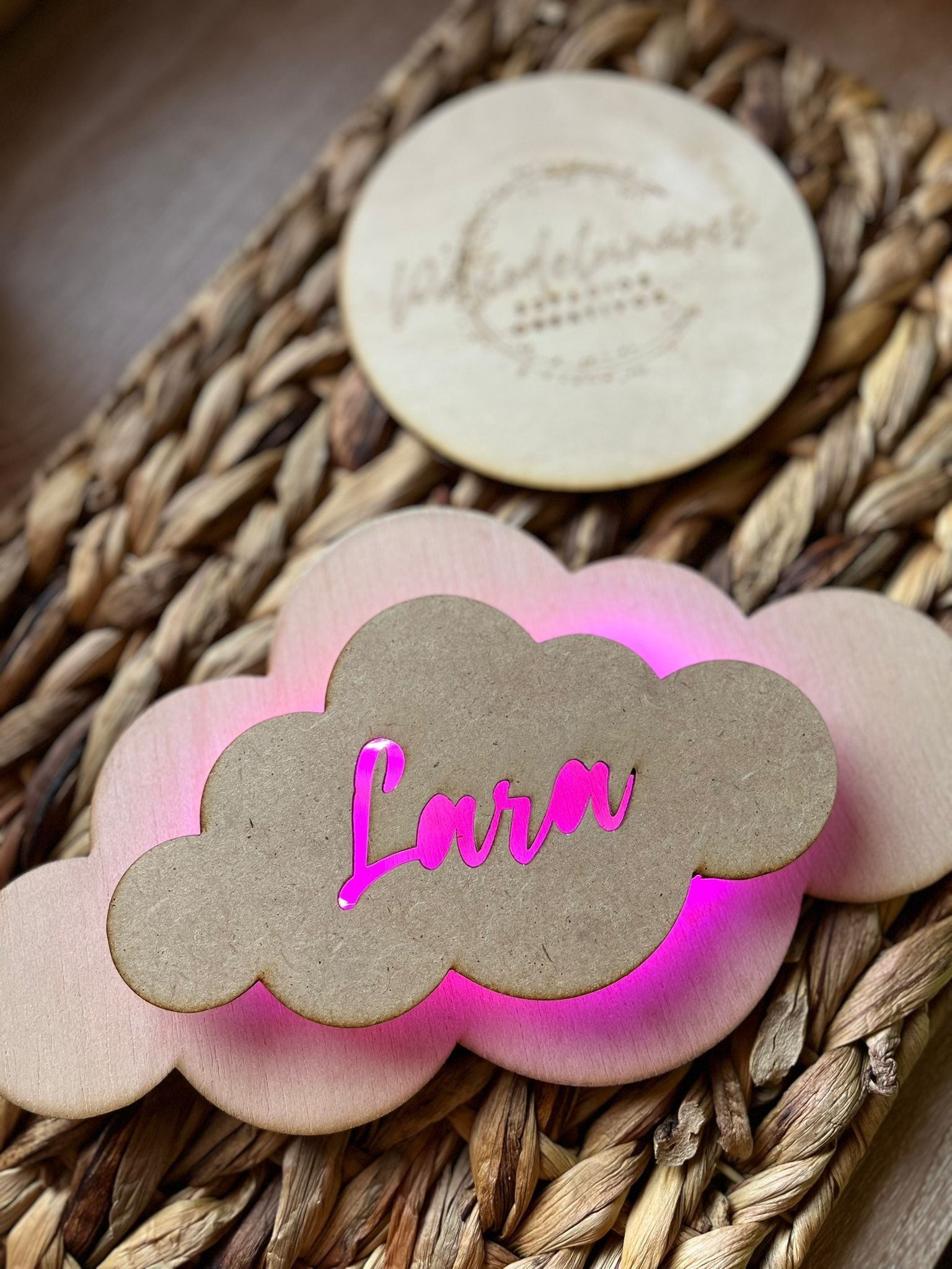 Un cartel de madera con forma de nube, con el nombre 