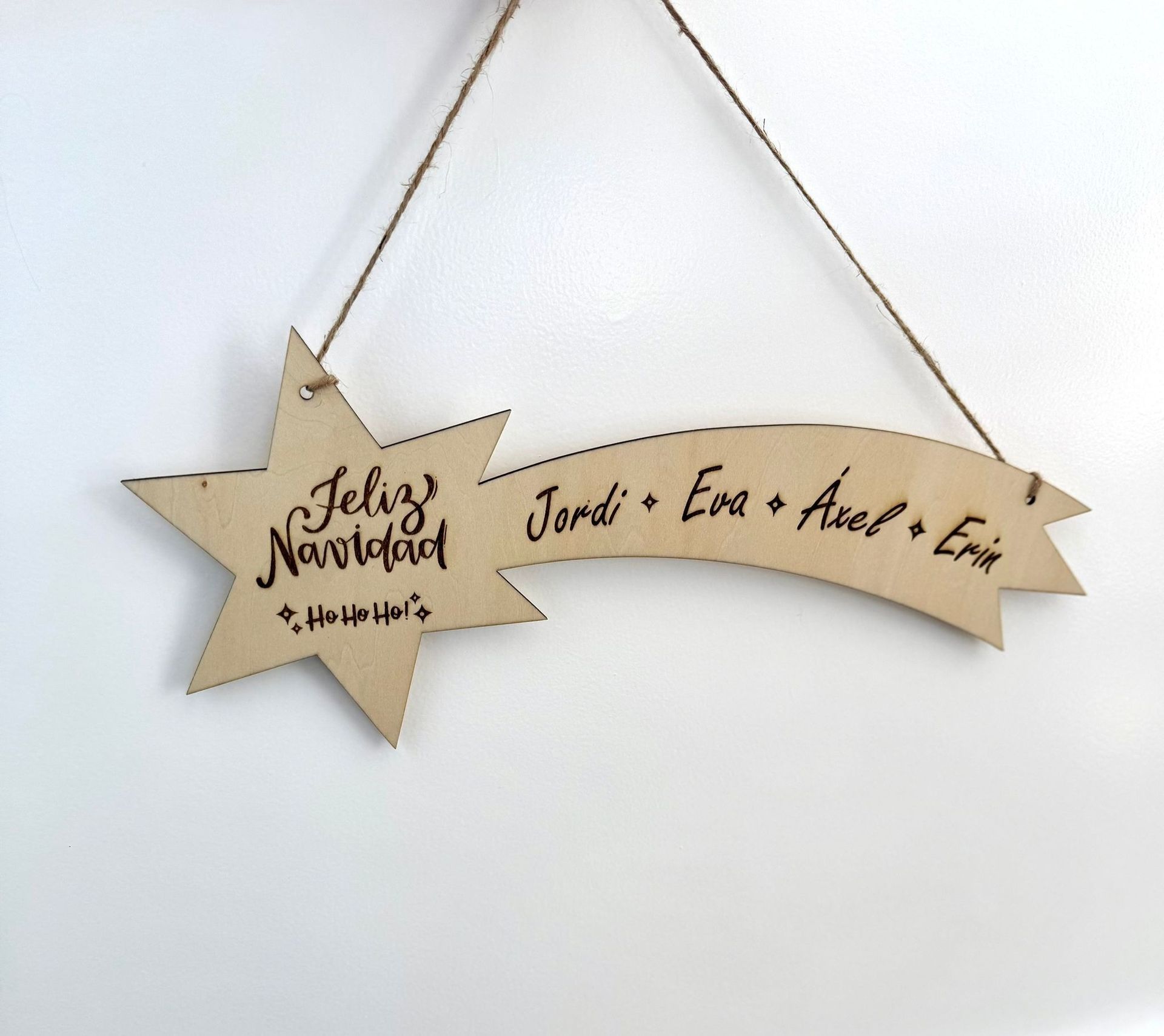 Un adorno de madera en forma de estrella fugaz con la inscripción 