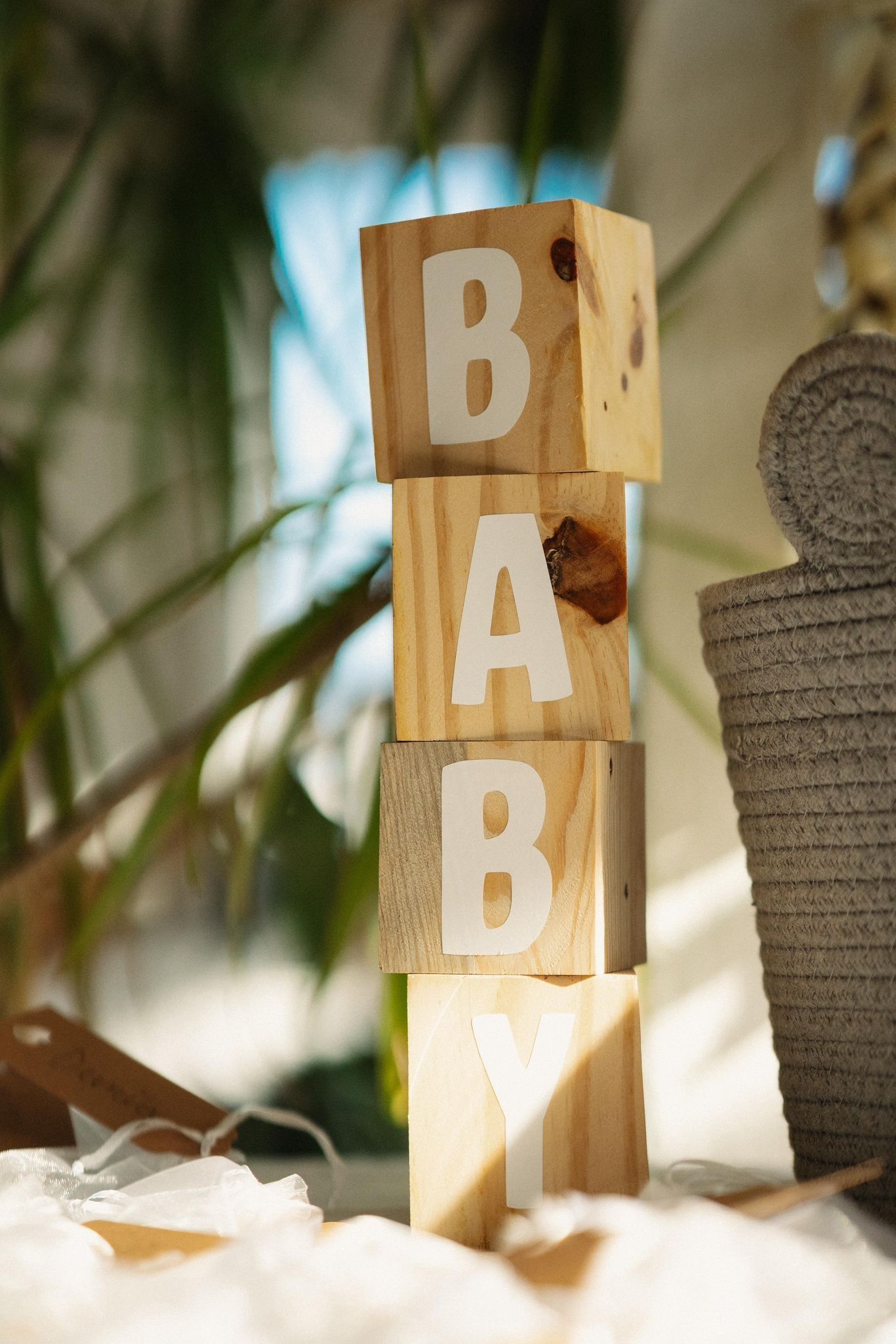 Una pila de cuatro bloques cuadrados de madera, cada uno pintado con una letra blanca para formar la palabra 