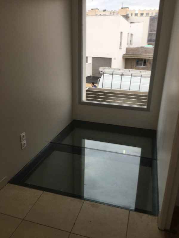 Dalle de sol en verre près d'une fenêtre.