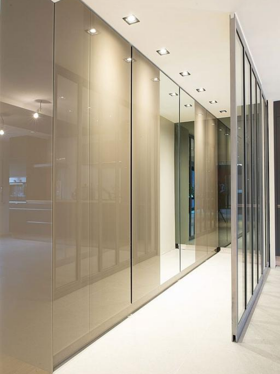 Couloir design équipé de cloisons vitrées et de placards laqués pour un intérieur contemporain.