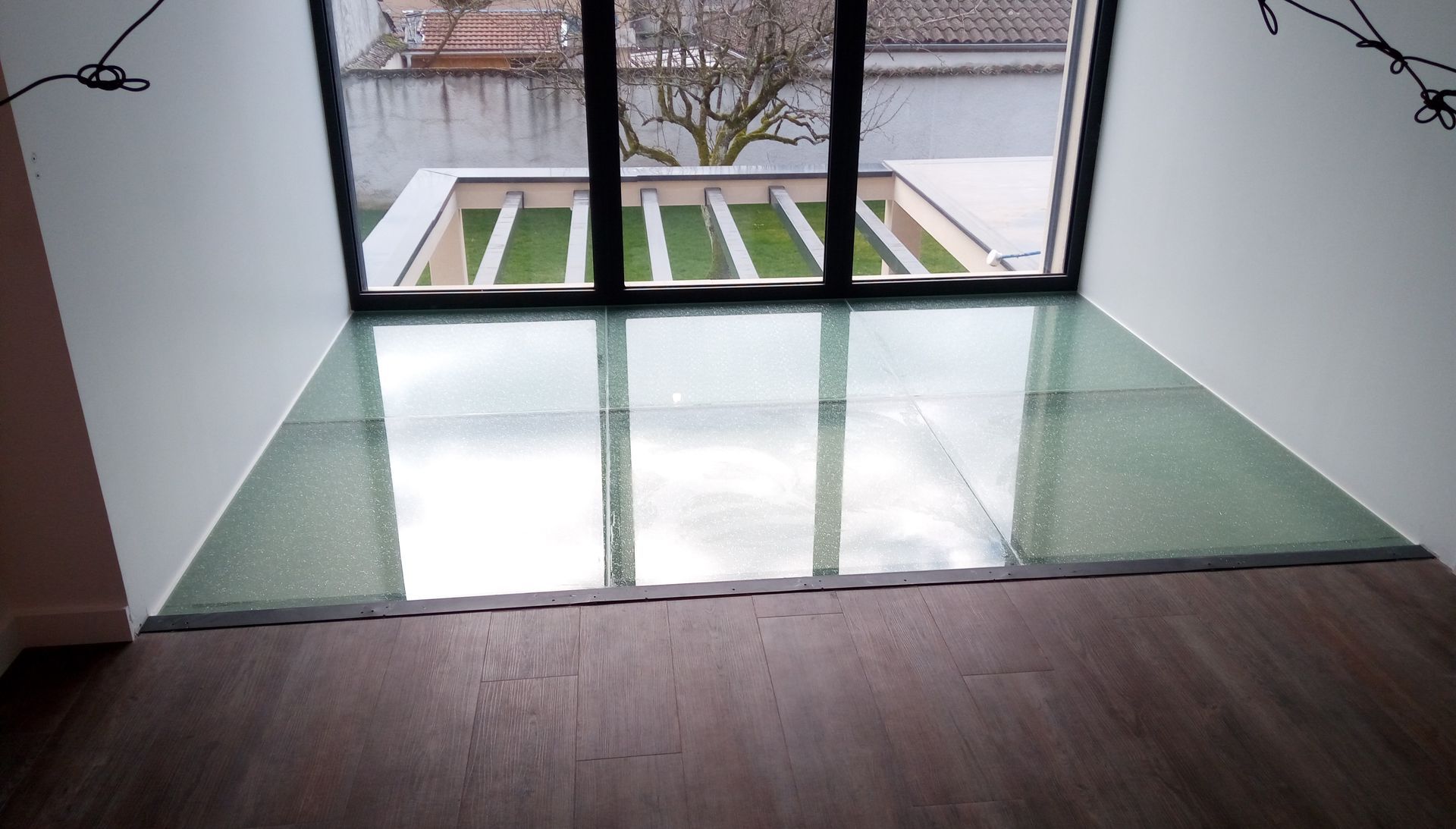 Dalles de sol en verre vues du dessus avec un film donnant un aspect brisé.