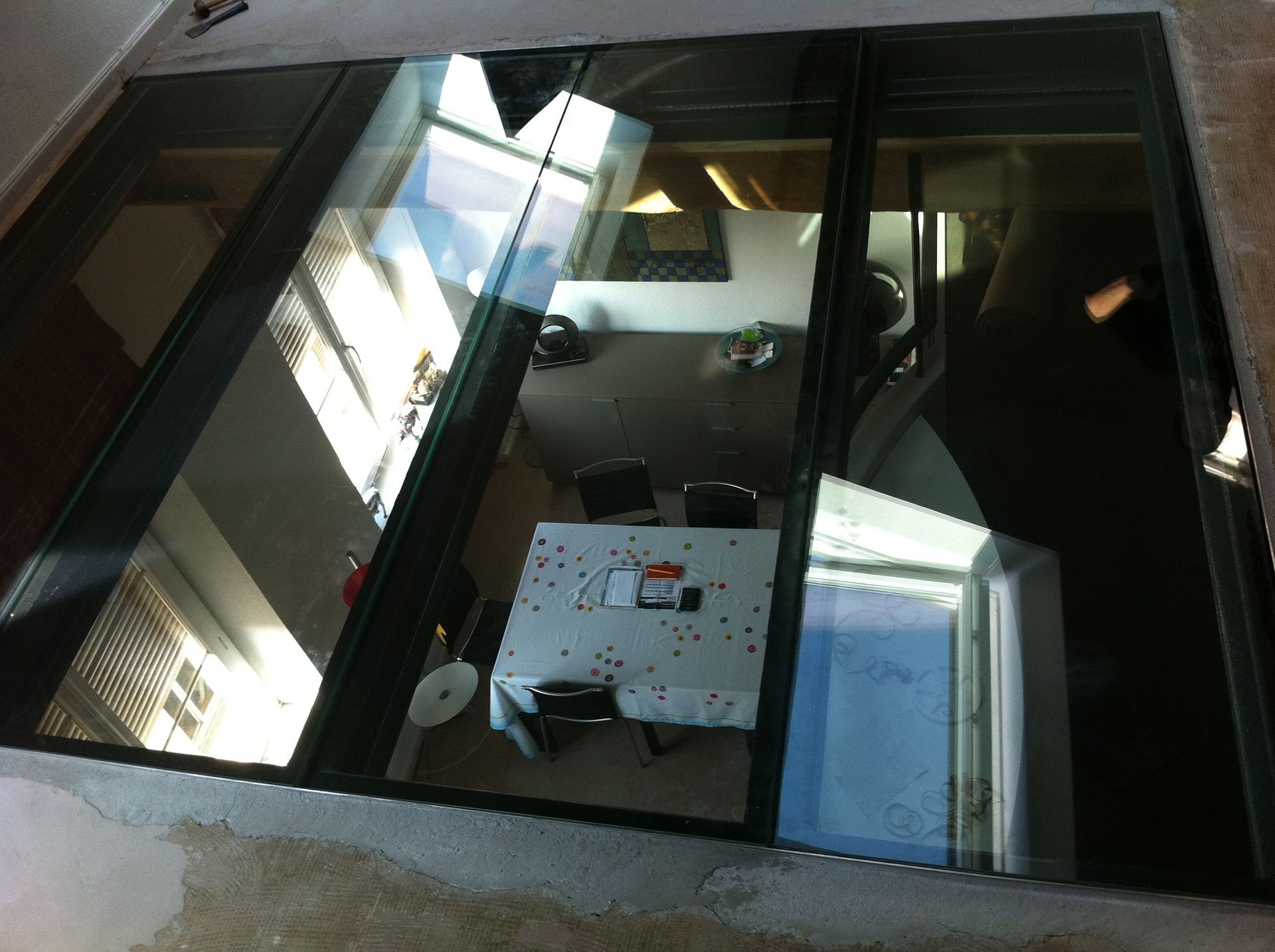 Dalle de sol en verre donnant sur une salle à manger.