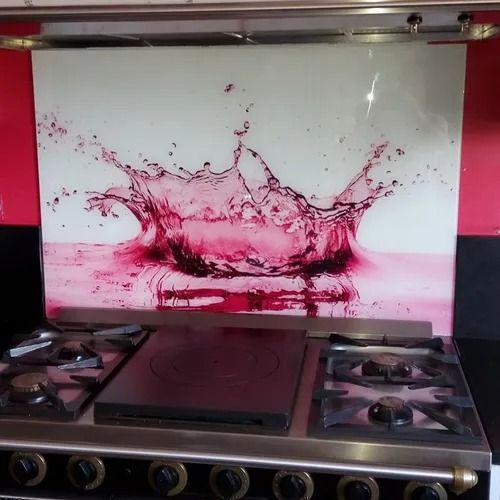 Crédence en verre ornée d'éclaboussures d'eau au-dessus d'une cuisinière à gaz.