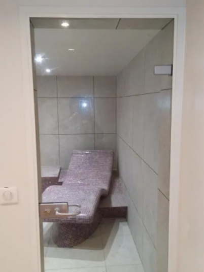 Porte intérieure en verre clair donnant accès à une pièce de détente.