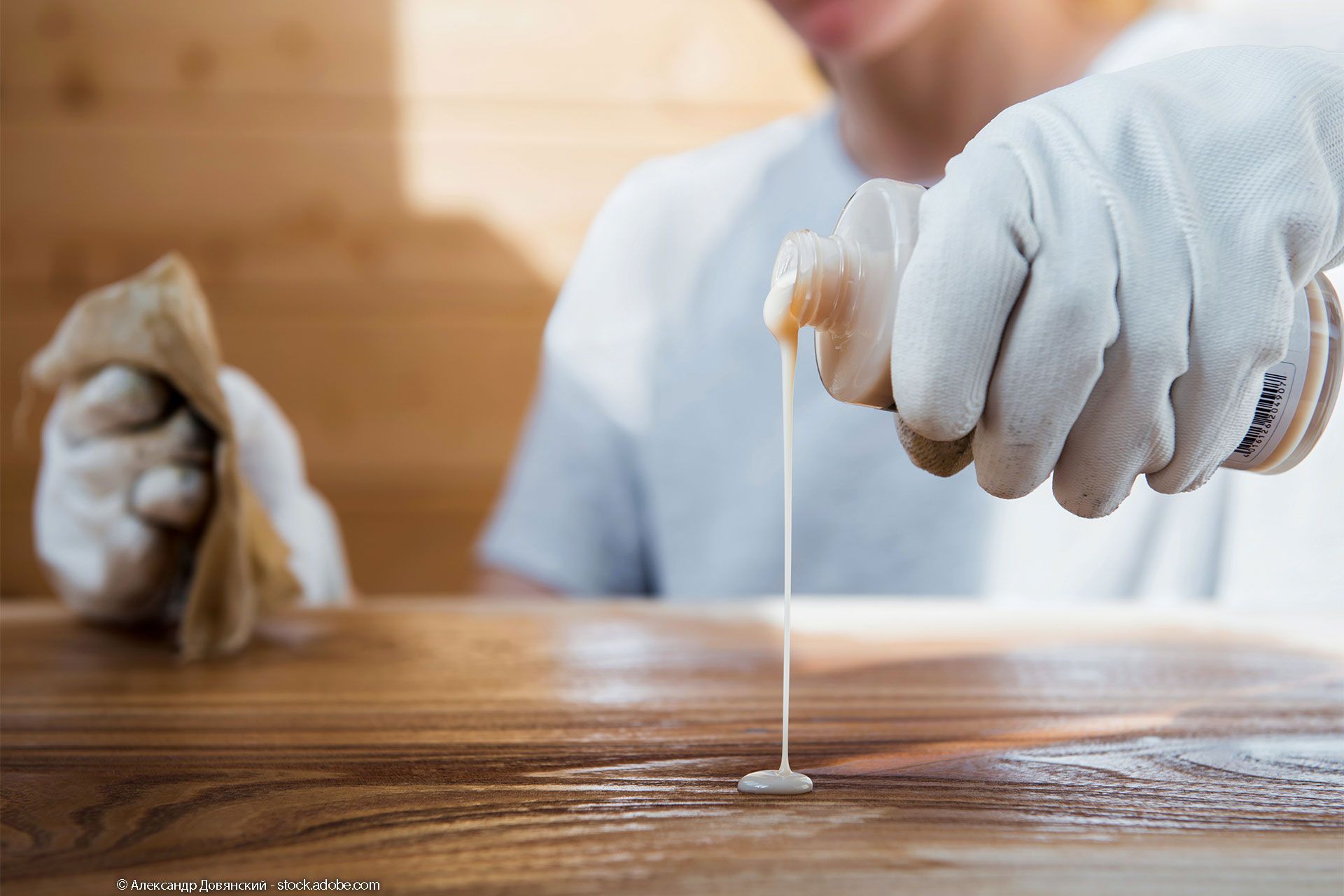 Junge Frau mit einem Pflegemittel für Holzmöbel 
