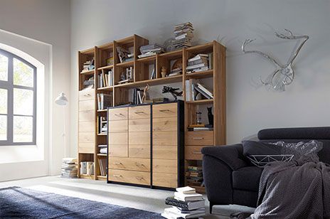 Wohnzimmer-Funktionswand aus Wildeiche mit Schränken umgeben von Regalen