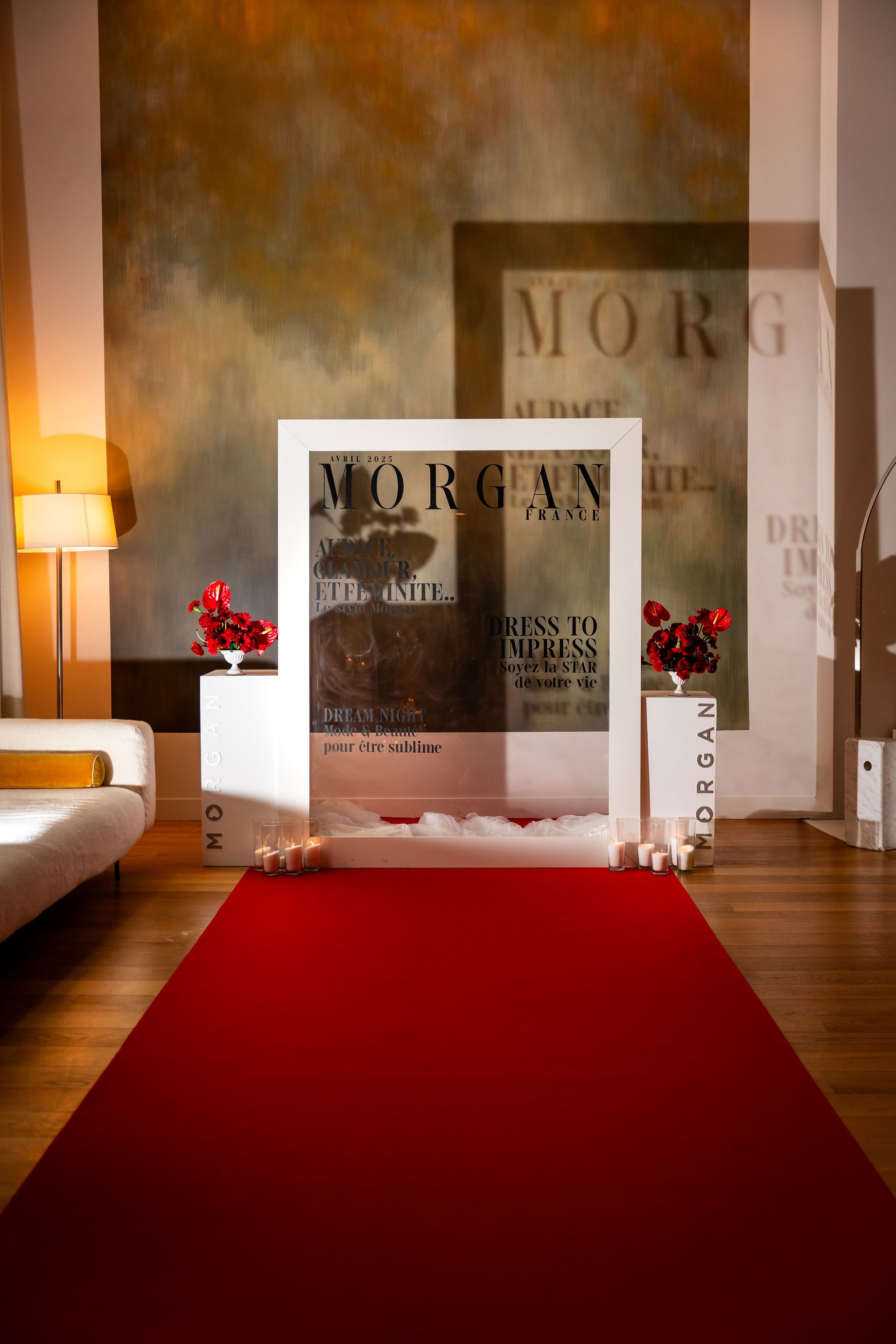 Un tapis rouge menait à des affiches encadrées de MORGAN dans un couloir intérieur baigné d'une lumière chaleureuse.