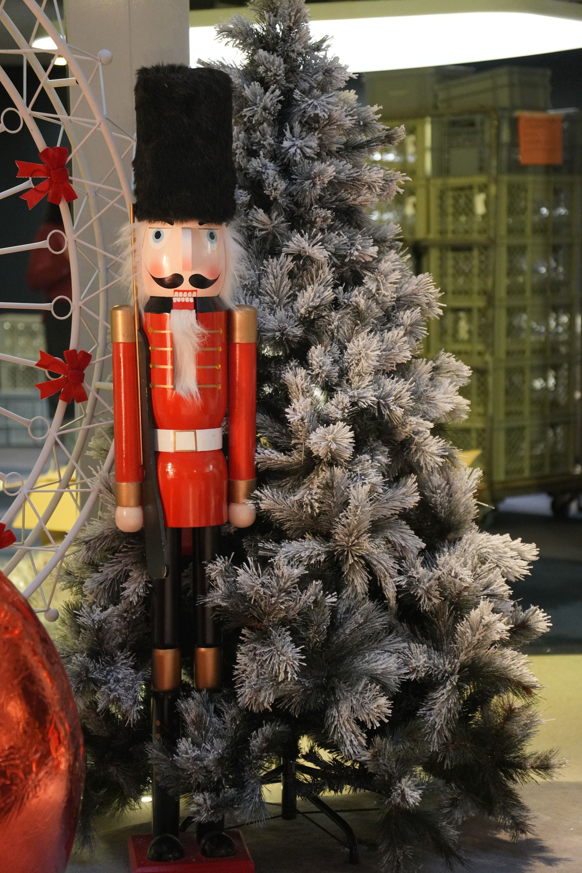 Casse-noisette en forme de soldat de plomb à côté d'un sapin de Noël givré à l'intérieur