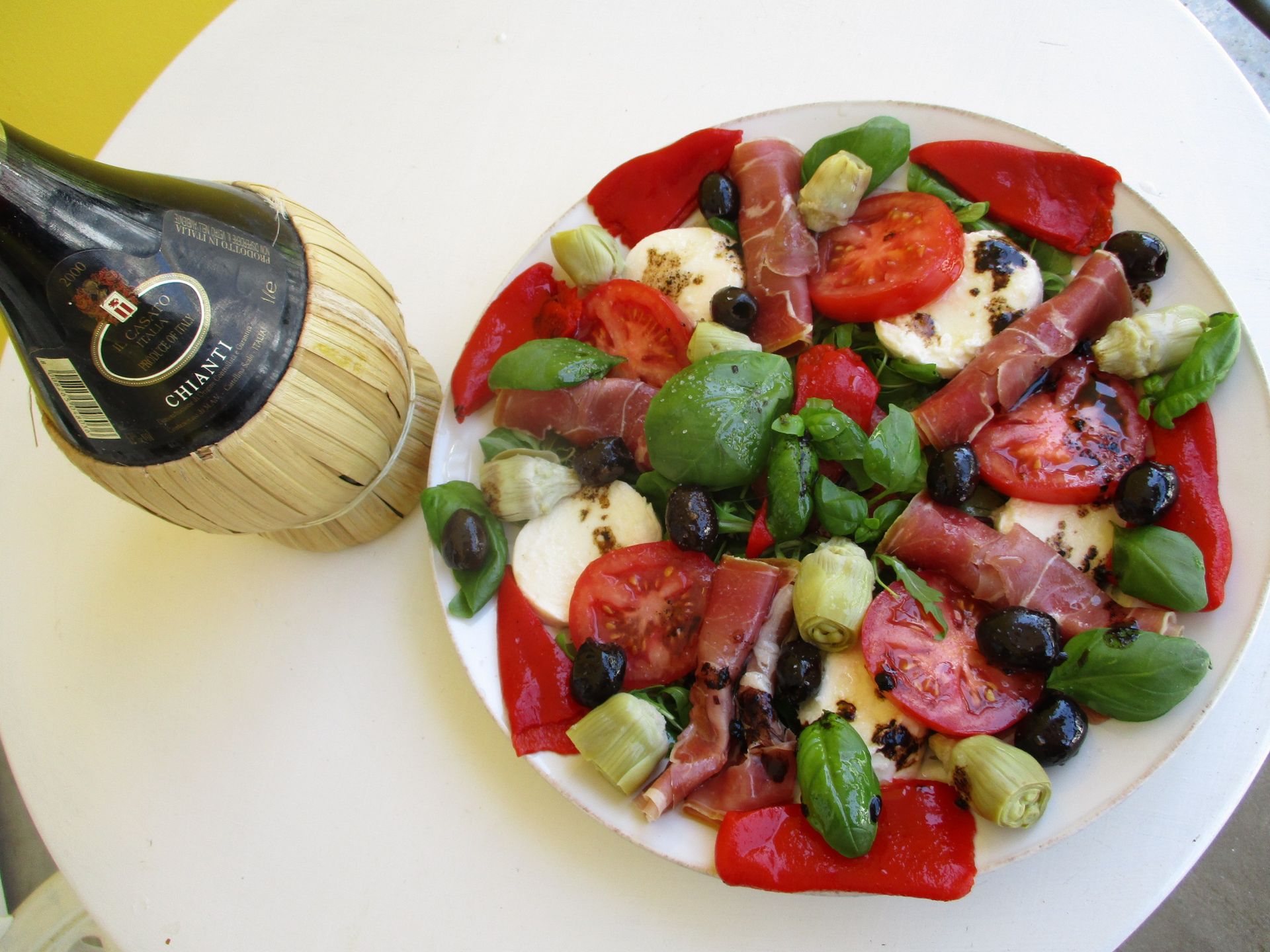 Salade composée colorée à la cuillère, avec une bouteille de champagne à proximité.