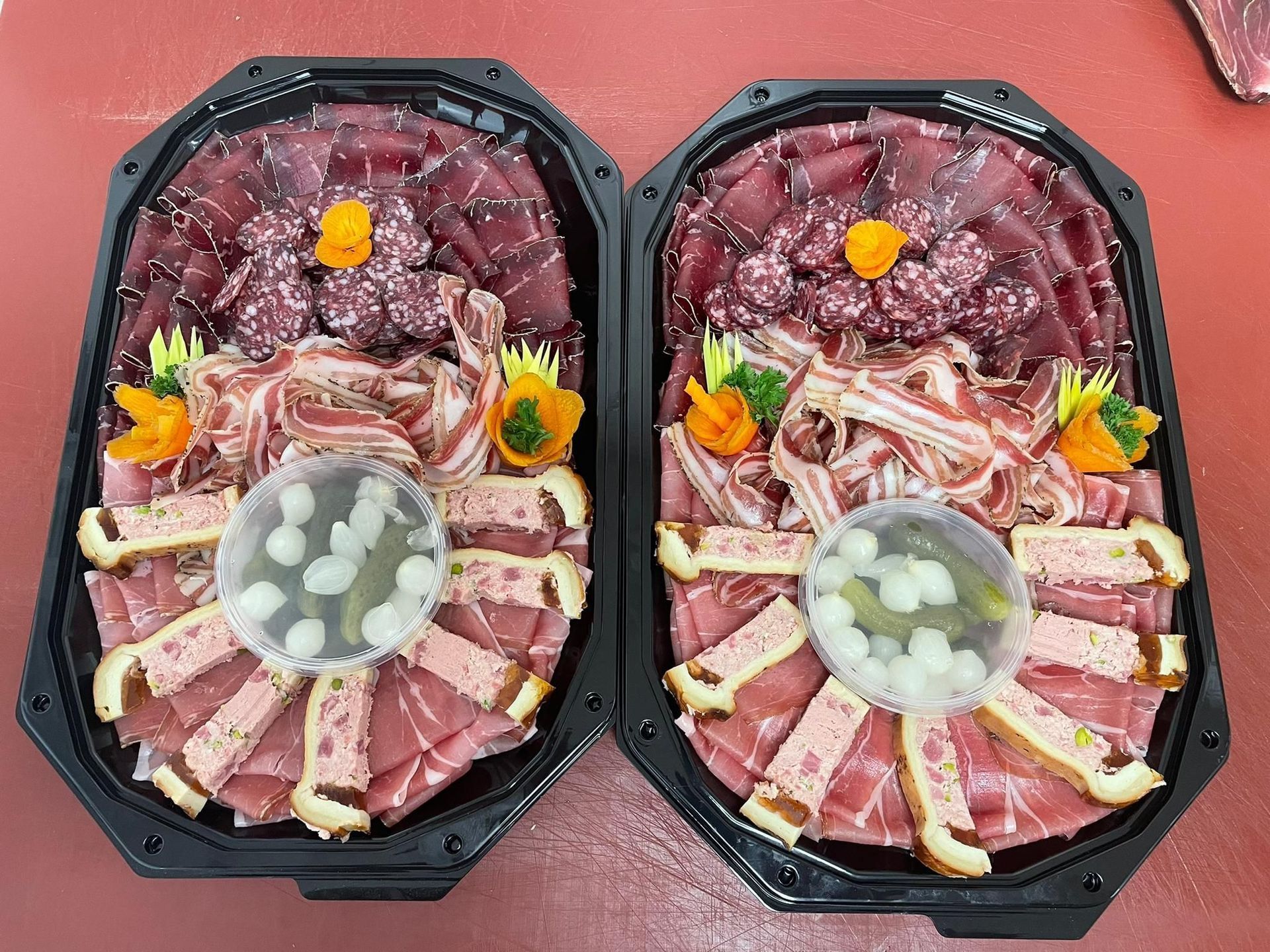 Deux plateaux de viande sont posés l'un sur l'autre sur une table.