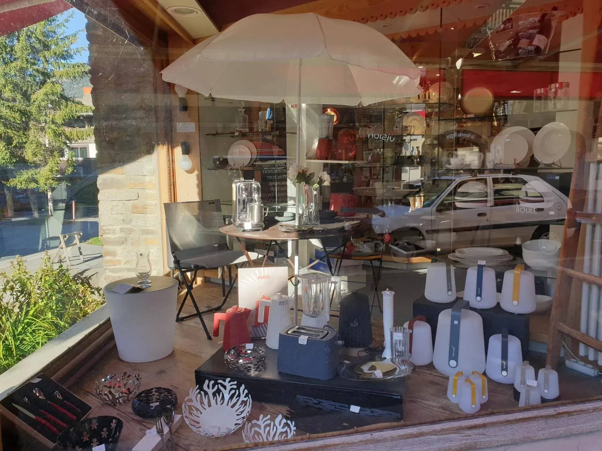 Présentation à ciel ouvert d'articles et d'ustensiles de cuisine sur des étagères et des tables en vitrine.