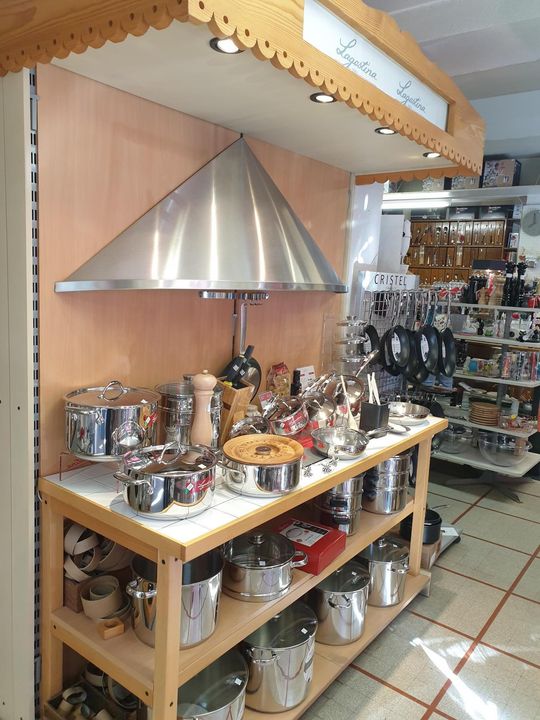 Cuisine aménagée avec hotte en acier inoxydable au-dessus d'un comptoir en bois présentant ustensiles de cuisine.