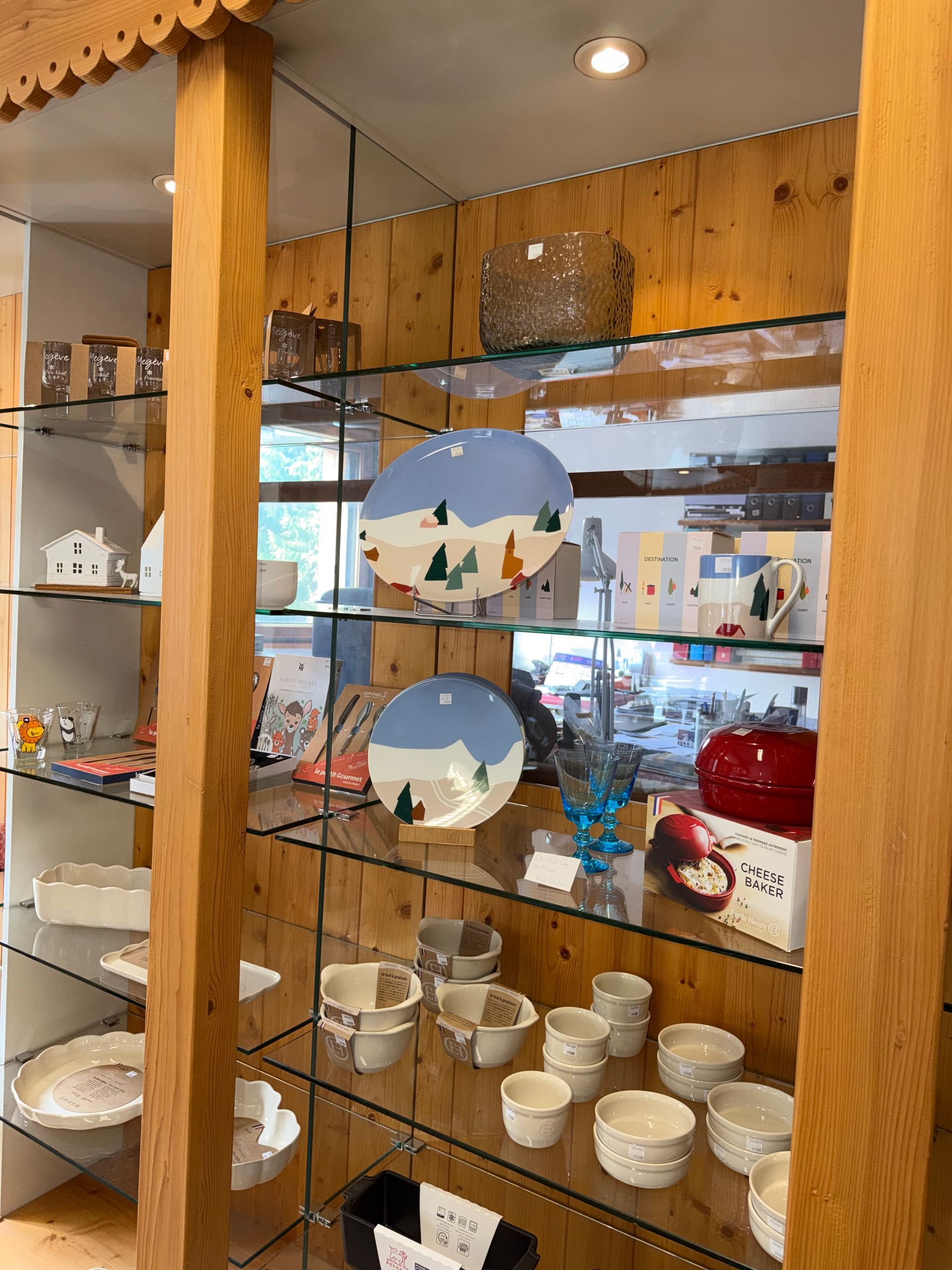 Étagères en bois présentant des tasses et des bols en céramique dans une vitrine de magasin.