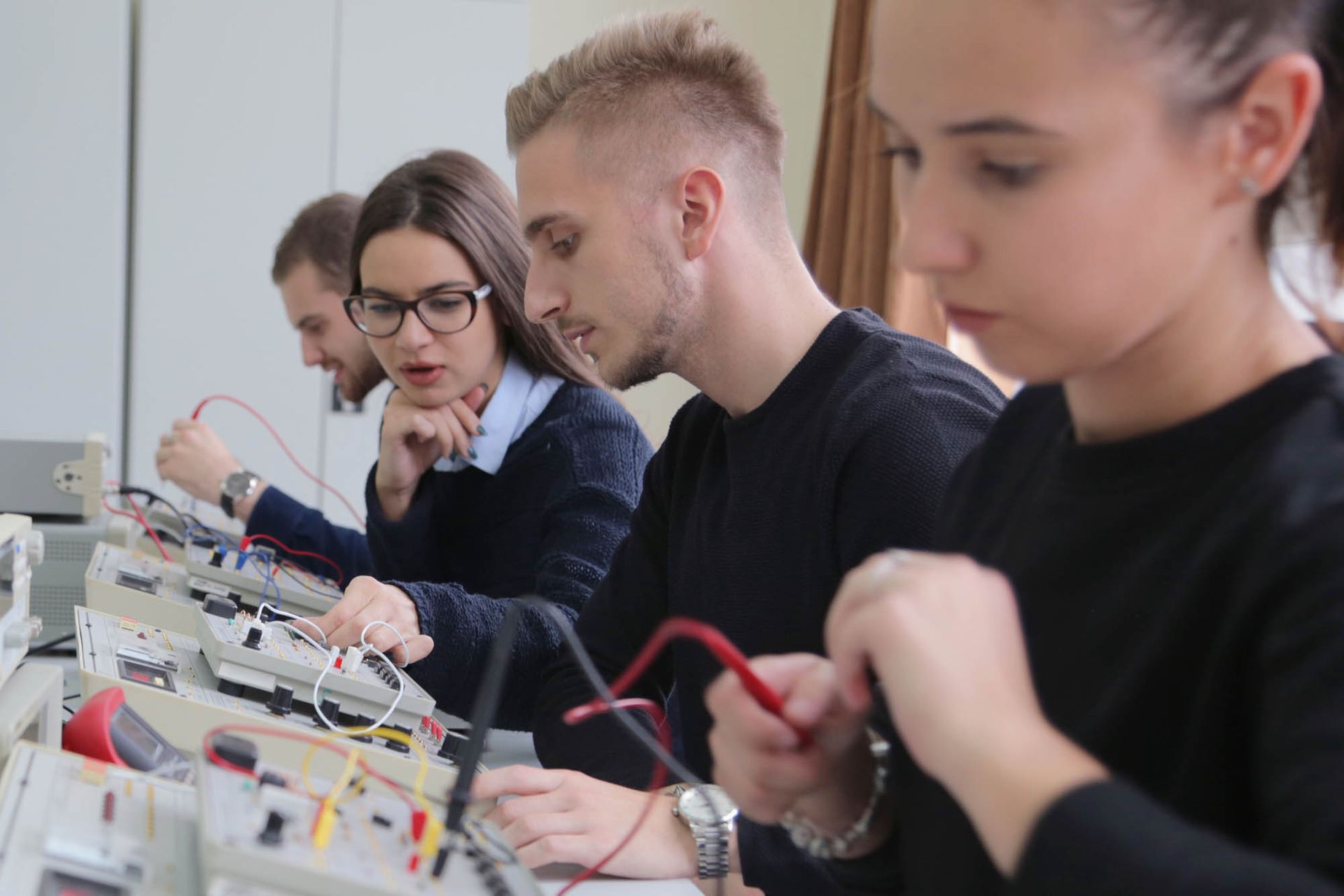 Eine Gruppe von Menschen arbeitet in einem Labor an Elektronik.