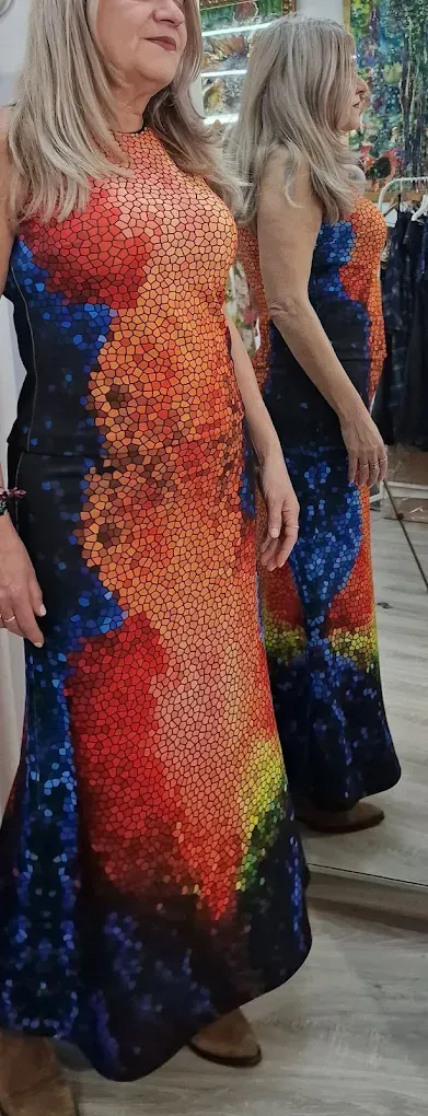 Una mujer está parada frente a un espejo con un vestido colorido.