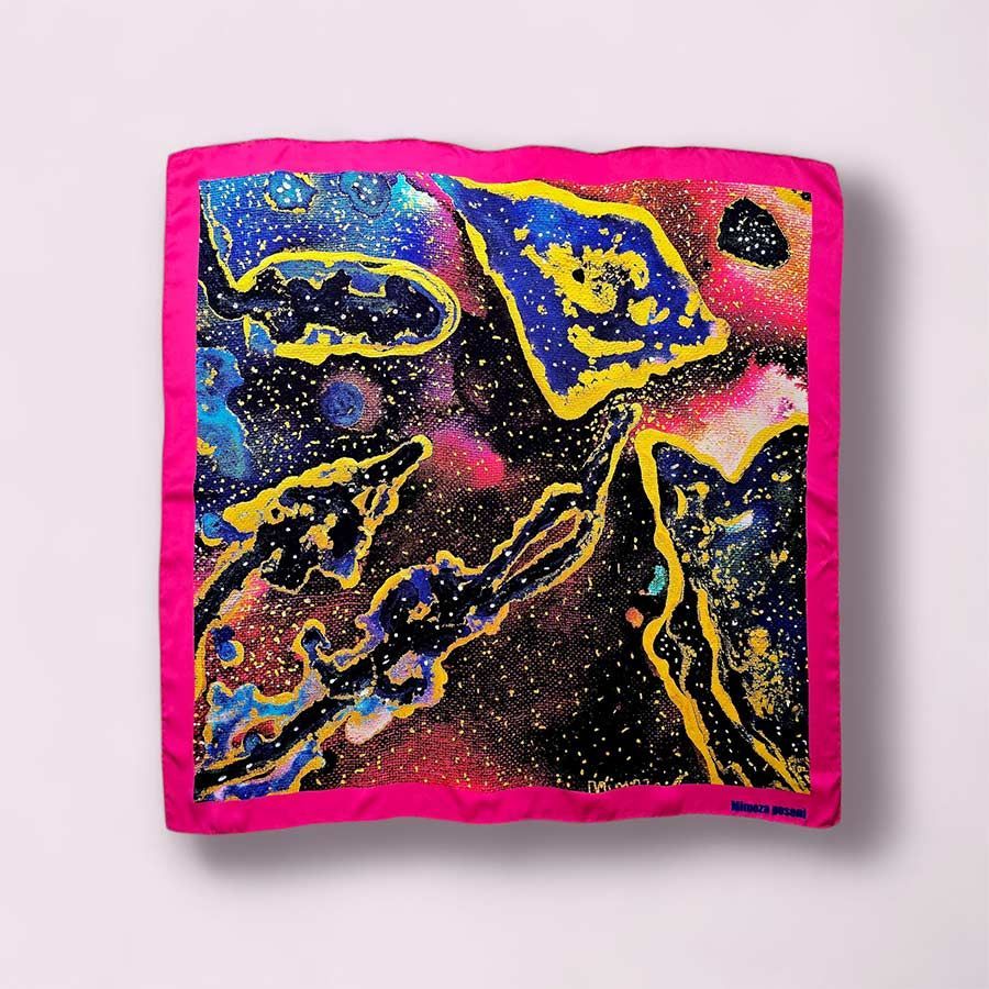 Pañuelo de seda rosa con dibujos abstractos en azul, amarillo y negro.