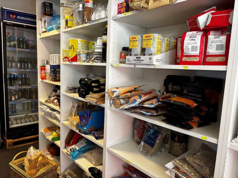 Regale voller verschiedener Süssigkeiten und Snacks in einem kleinen Gang eines Convenience-Stores
