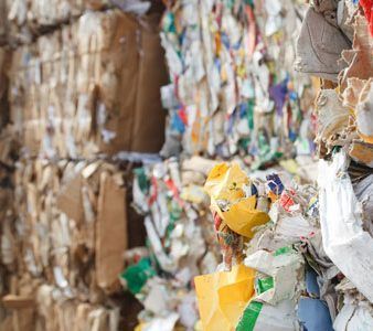 Gros plan sur des balles compressées et empilées de papier et de carton recyclés.