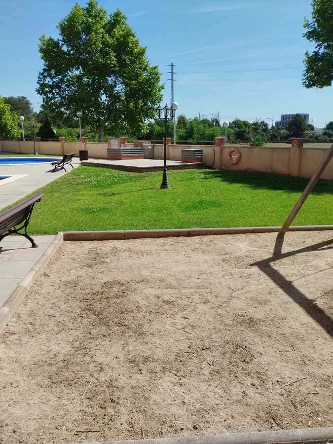 Un parque con un columpio y un banco en primer plano.