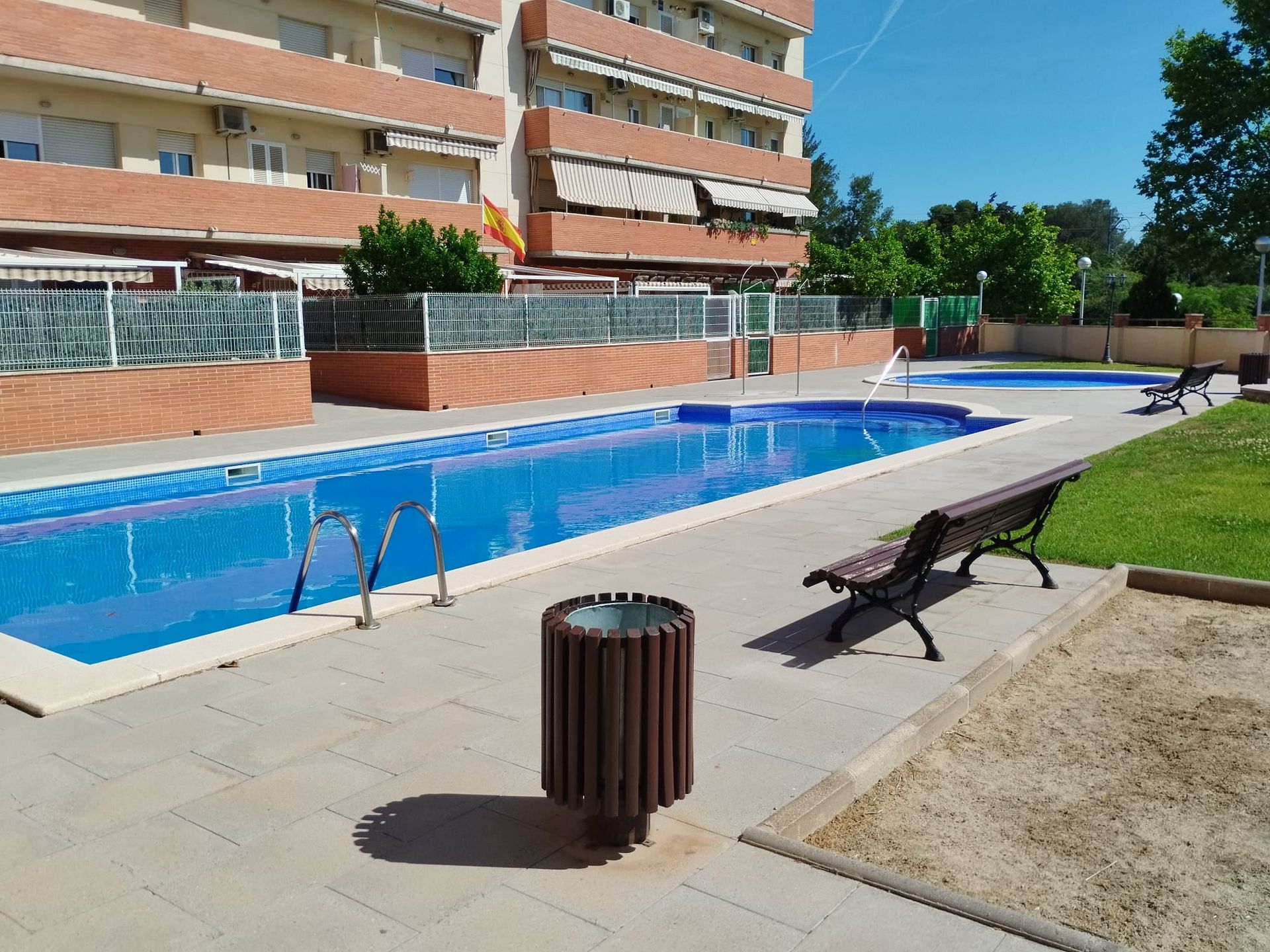 Una gran piscina con un bote de basura enfrente.