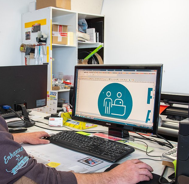 Graphiste suivant un brief et travaillant sur un ordinateur