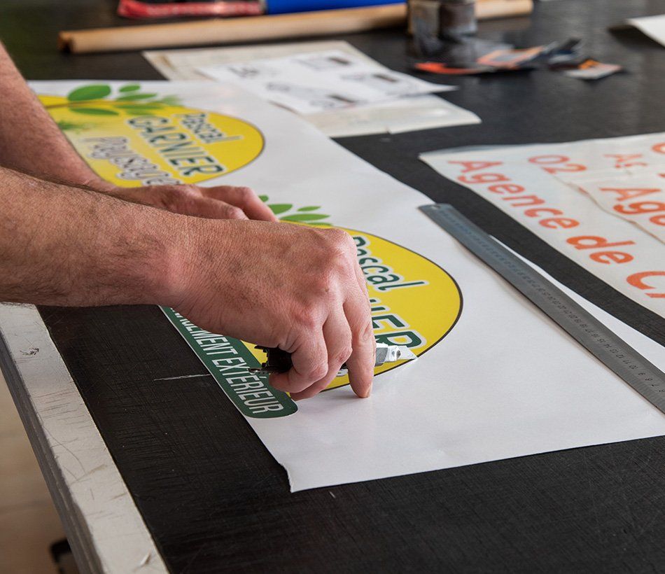 Découpe d'éléments imprimés sur du papier autocollant