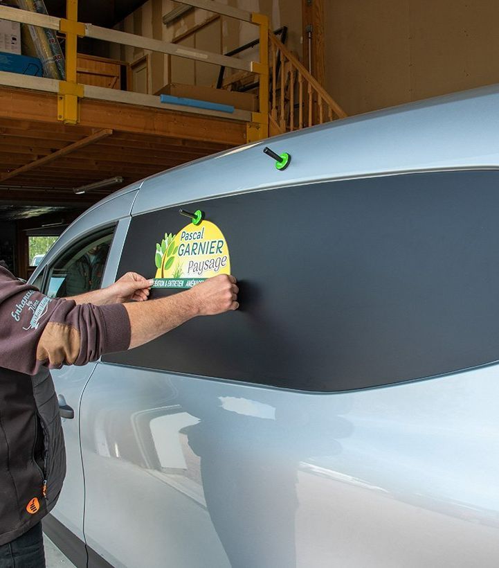 Employé qui pose un autocollant sur un véhicule