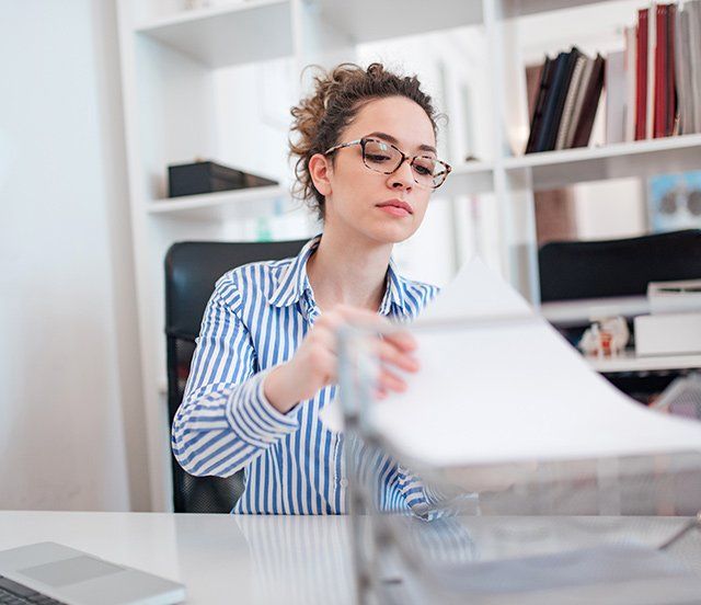 Femme dans un bureau de travail tenant un document administratif