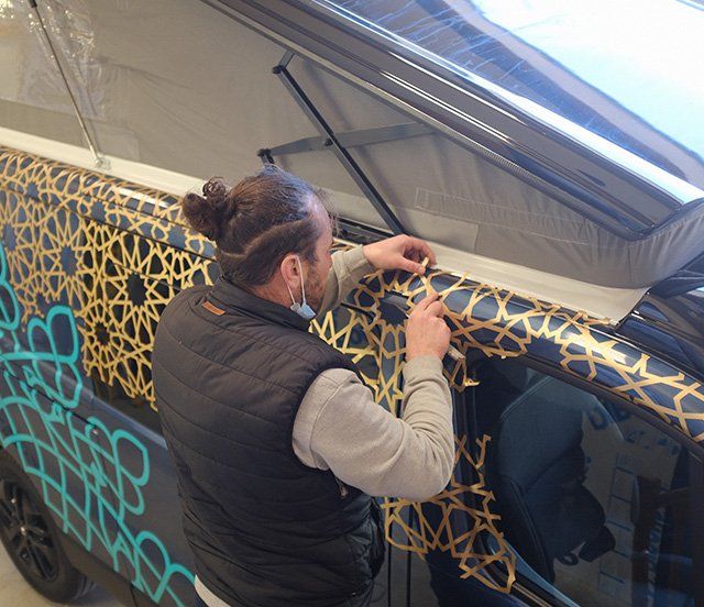 Ouvrier posant un film autocollant sur un véhicule