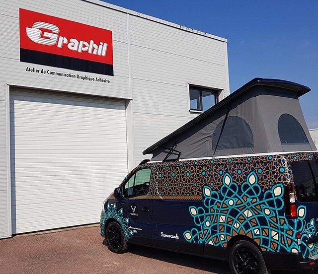 Véhicule floqué avec soin garé devant l'enseigne Graphil