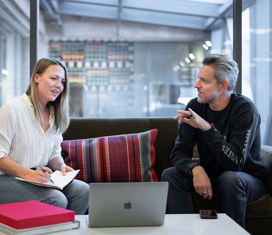 Discussion entre deux personnes assises sur un canapé