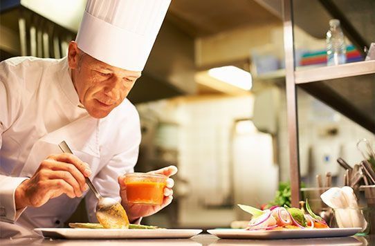 Un chef está preparando un plato de comida en una cocina.
