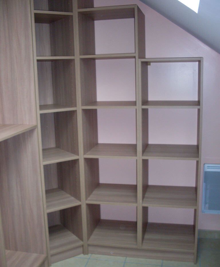 Étagère beige vide encastrée dans un mur rose clair.