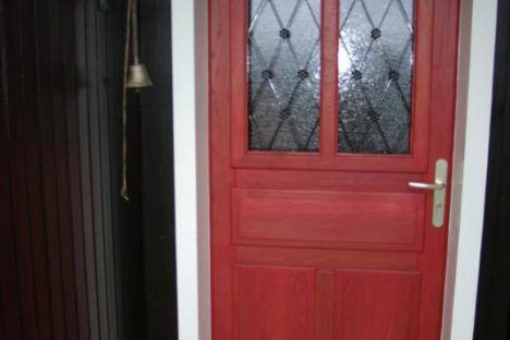 Porte d'entrée en chêne lasurée rouge