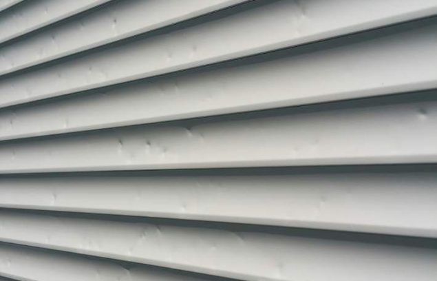 Bardage horizontal blanc, présentant des lignes parallèles avec de légères indentations.