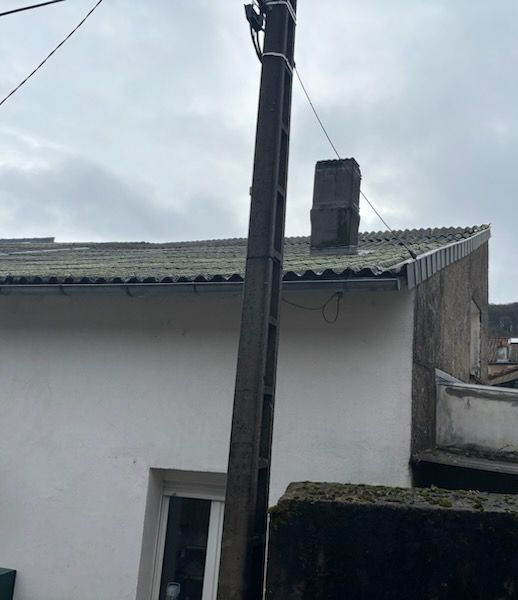 Poteau électrique à côté d'une maison