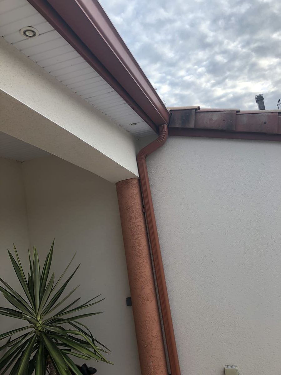 Gouttière et descente d'eau en zinc couleur brique