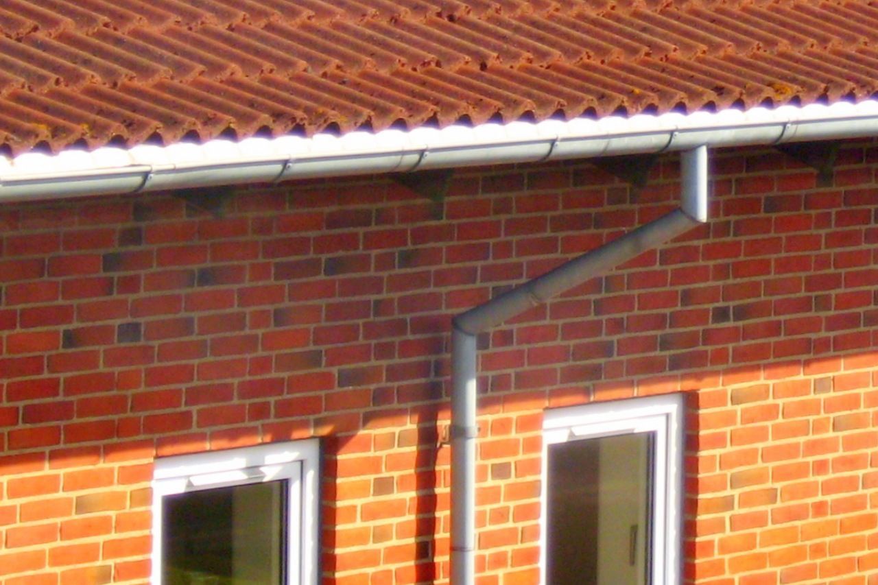Maison avec un mur en brique et une gouttière