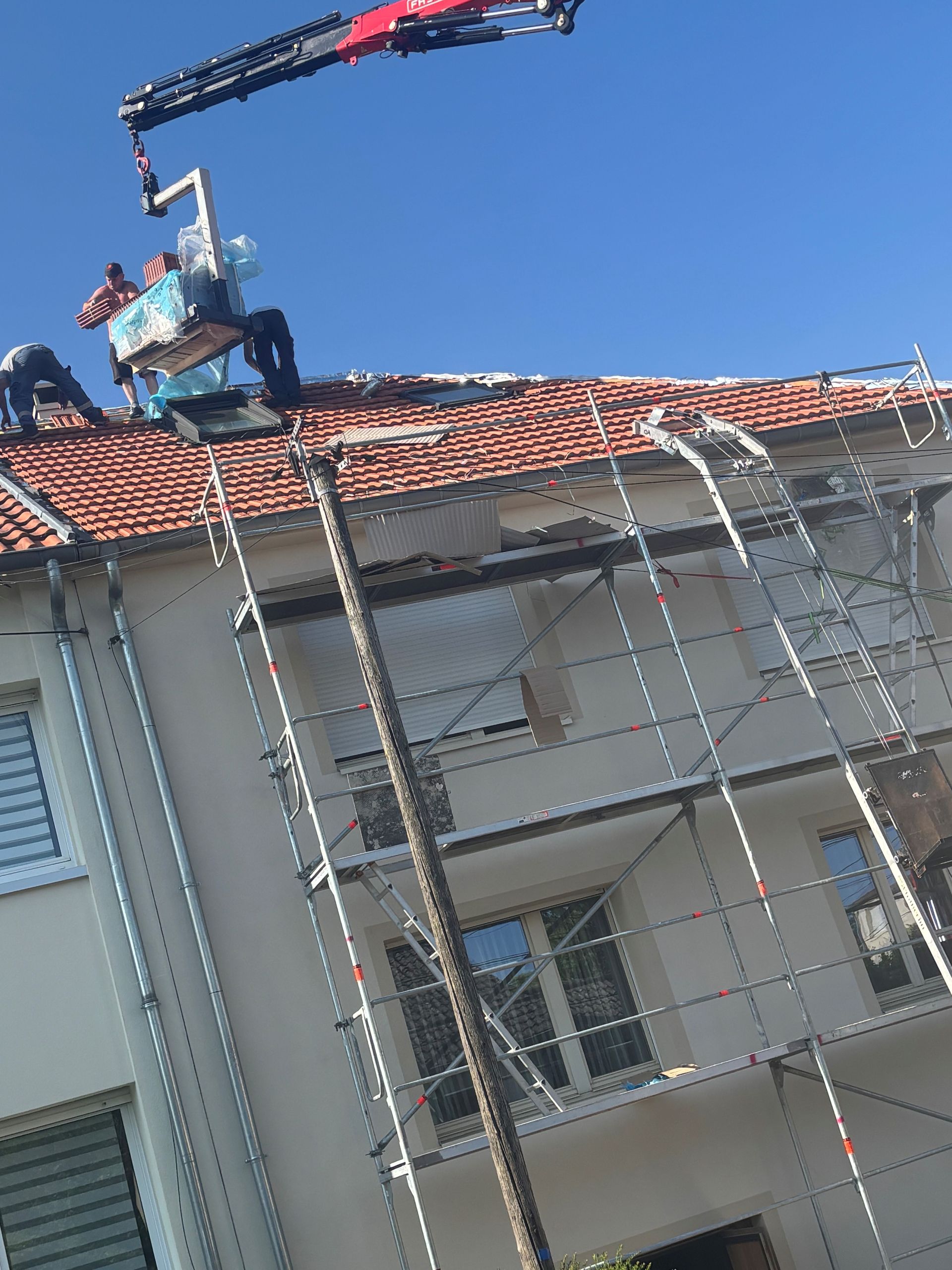 Technicien déchargeant une grue sur un toit