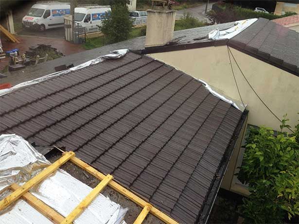 Toiture avec une partie recouverte d'une bâche plastique isolante