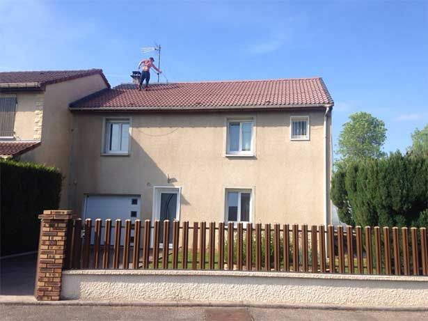 Maison beige avec un professionnel sur le toit