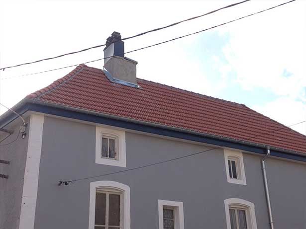 Maison avec toiture en bon état et ayant une façade grise