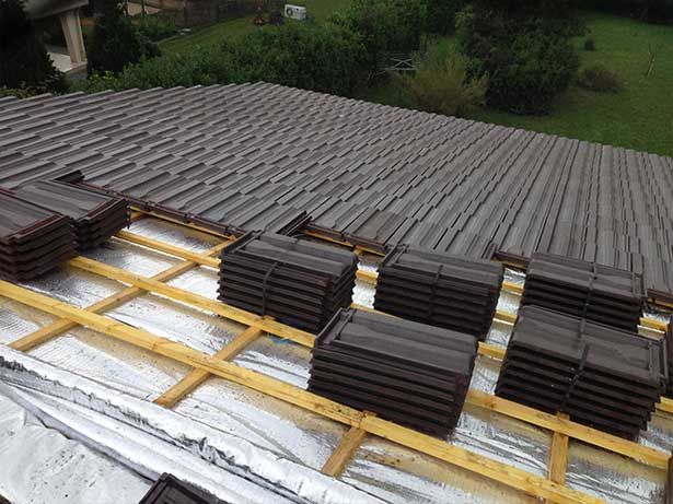 Couverture d'un toit avec la pose de tuiles foncées