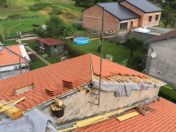 Travaux de couverture d'une maison avec un toit en tuiles