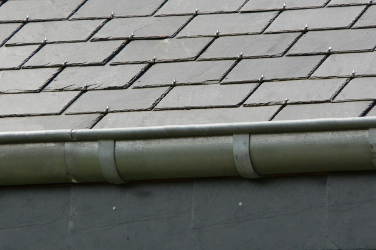 Gouttière d'une maison avec un toit en ardoise