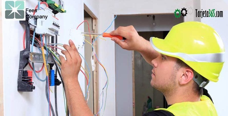 Un electricista está trabajando en una pared con un destornillador.