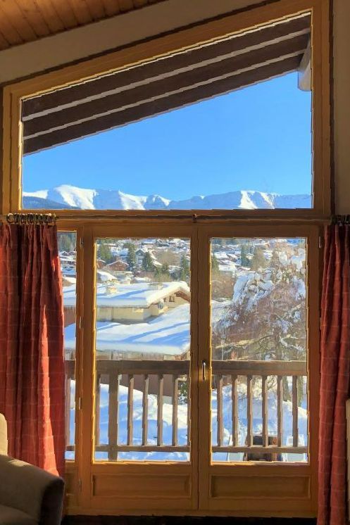 Fenêtre en bois donnant sur les montagnes