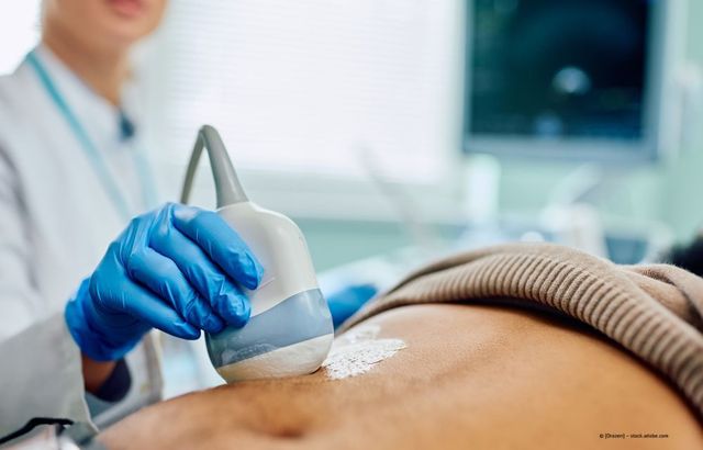 Medizinisches Fachpersonal verwendet während einer Ultraschalluntersuchung eine Ultraschallsonde am Bauch eines Patienten.
