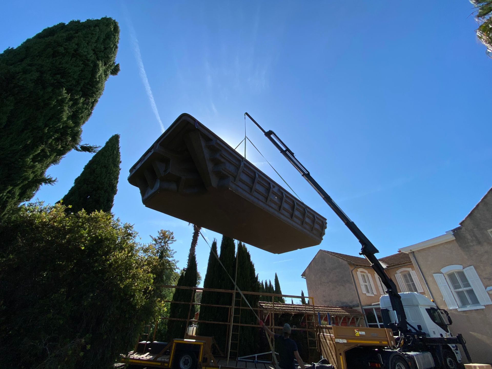 Une grue soulève une piscine coque.